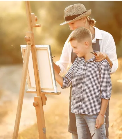 Caregiver and Child Painting on Easel